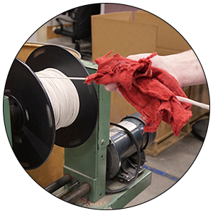 Person handling cable on a re-spooling machine.