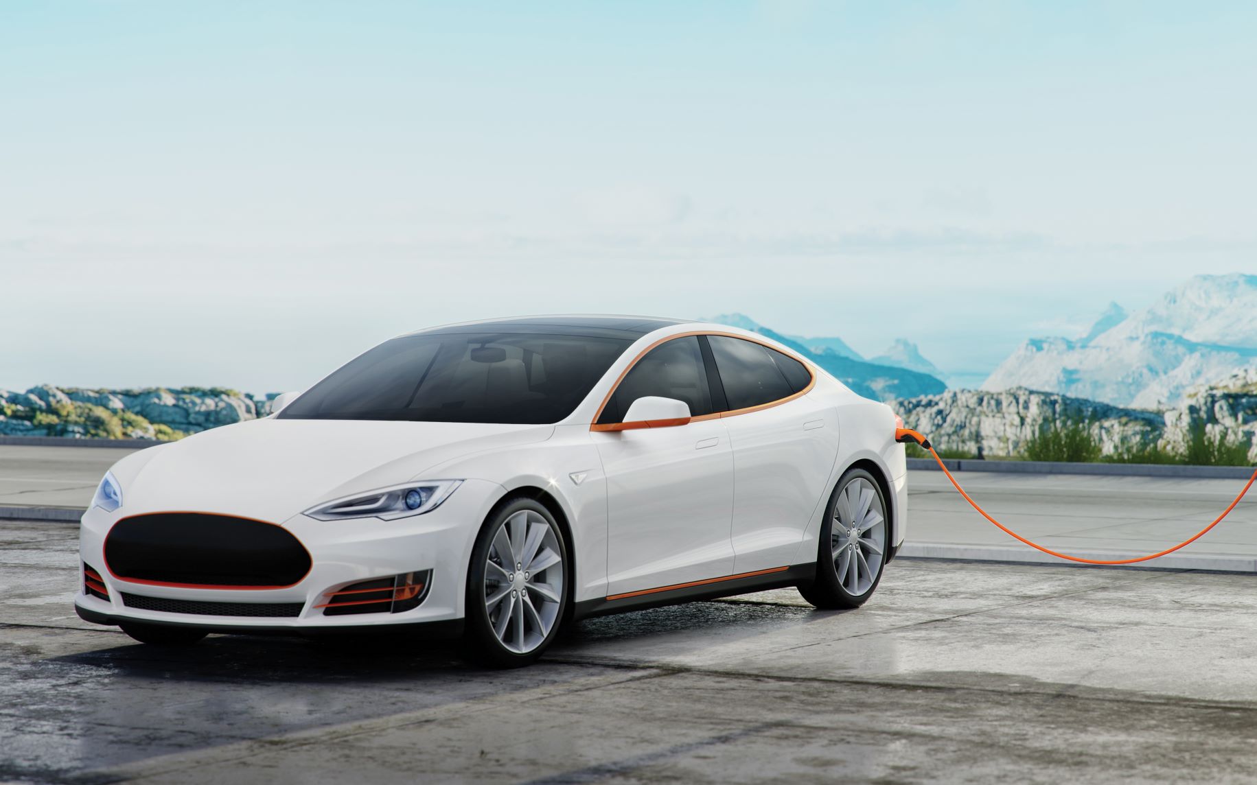 White electric vehicle plugged into a charging station with mountains in the background.