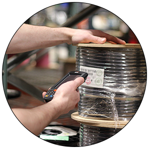 Quick Pick Inventory Management Person using a Quick Pick scanner on large black cable on a warehouse shelf.